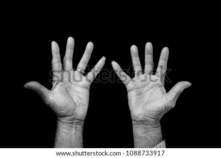 Black and white photograph of an adult African American male's hands, held out in a giving or accepting gesture: open, palms up, fingers apart. Wedding ring visible. Solid black background.