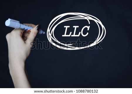 The businessman writes an inscription with a white marker:LLC