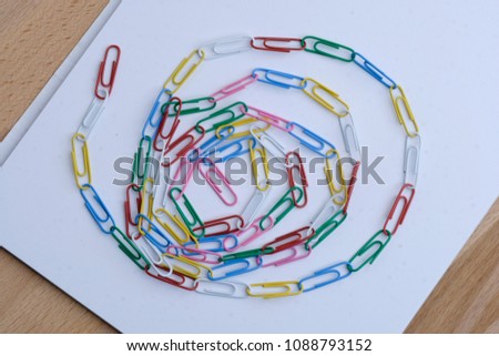 Lots of paperclips linked together and form a spiral design