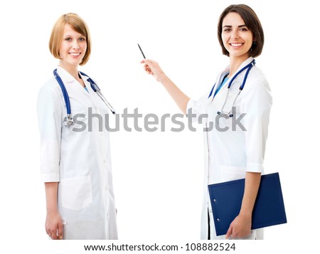Two pretty female doctors show something on a white background