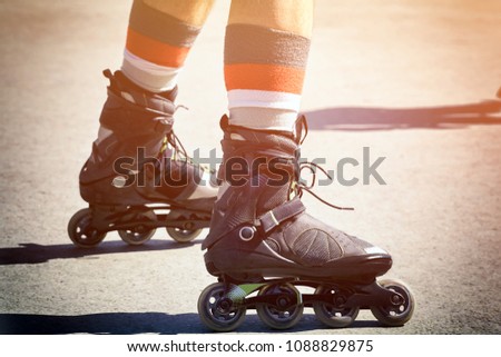 The guy goes rollerblading on the asphalt. Closeup of foot in roller skates. The concept of recreation and healthy lifestyle.