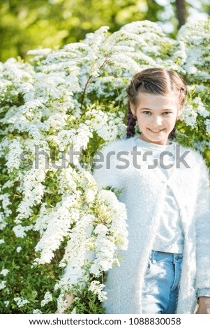 Beautiful happy girl smiling and laughing. Summer flowering tree. White flowers