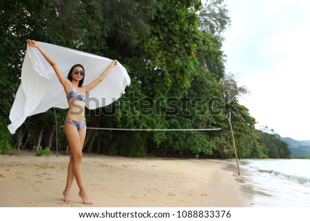 Asian Tanned Skin Girl stand on Beach with green tree, copy space for text logo