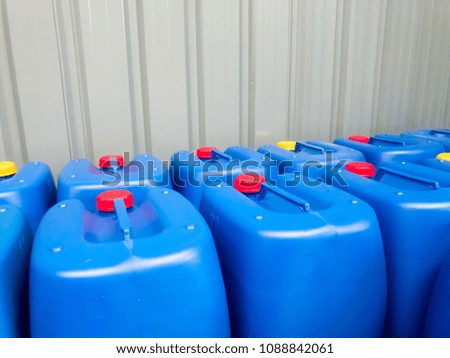 Group of Blue plastic container with red and yellow screw cap stack in the warehouse storage.