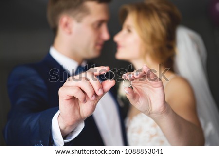 The bride and groom are holding wedding rings. Wedding rings close-up. Focus on wedding rings, unfocus the bride and groom Royalty-Free Stock Photo #1088853041
