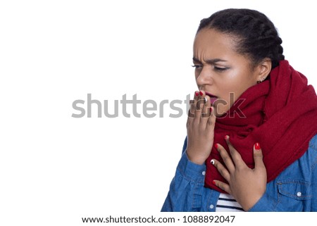 Young beautiful woman wearing a scarf coughing isolated on white. Studio close up shot of an attractive African woman looking sick and ill. Healthcare, medicine, seasonal flu concept