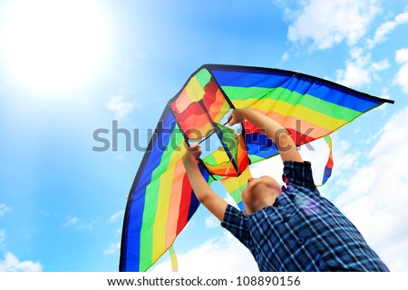 Little boy flies a kite into the blue sky Royalty-Free Stock Photo #108890156