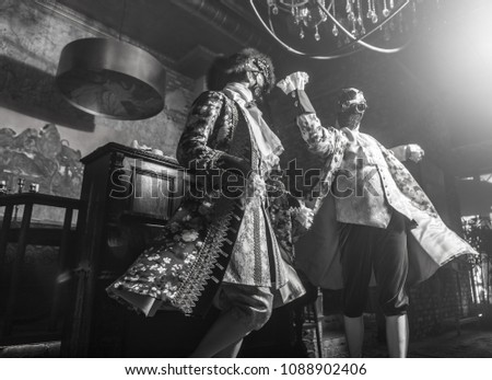 Actors in Steam punk masks and antique costumes indoor. Black-white photo.