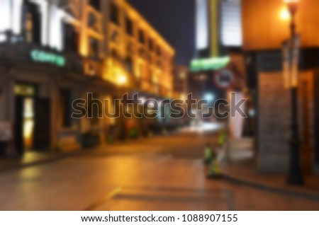 Blurry background texture of commercial street at night in urban city environment.