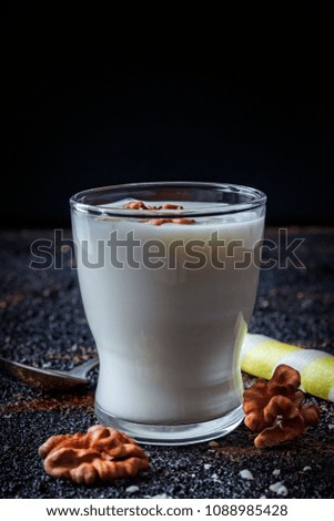 Layered greek yogurt parfait with nut and cornet in a glass. Healthy breakfast. Dark food photography. Close up, vertical