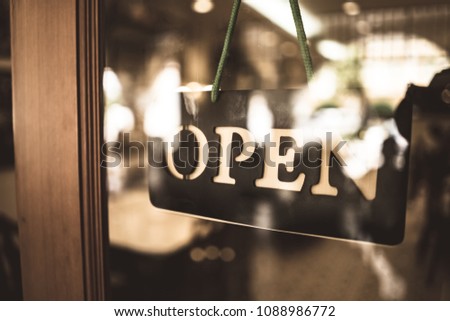 Open sign broad through the glass of door in cafe. Business service and food concept. Vintage tone filter effect color style.