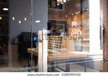 Open wooden sign broad through the glass in street cafe