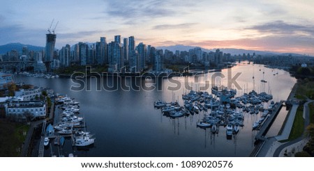 Striking aerial panorama of a beautiful city during a vibrant cloudy sunrise. Taken in False Creek, Downtown Vancouver, British Columbia, Canada.