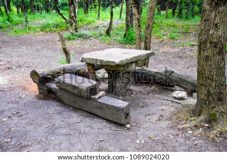 A homemade table and benches in the forest.