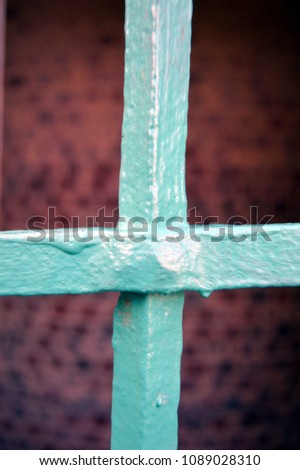 teal iron bars cross and letter t