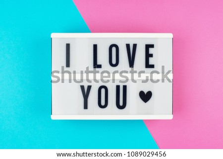 I Love You - text on a display lightbox on blue and pink bright background.