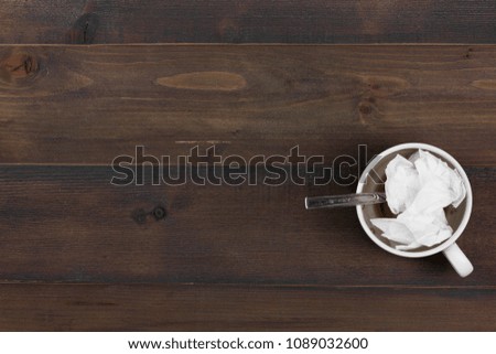 Empty coffee cup with tissue after drinking on wooden background - free text space.