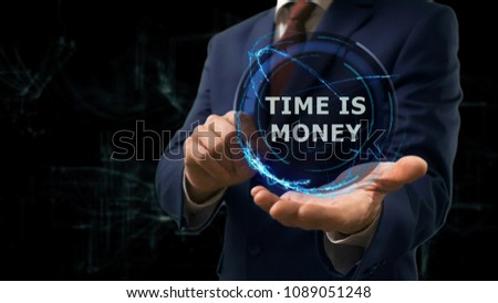Businessman shows concept hologram Time is money on his hand. Man in business suit with future technology screen and modern cosmic background