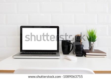 Conceptual workspace, Laptop computer with blank white screen on office table, white background.