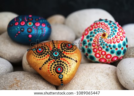 Beautiful hand painted mandala stones lies on the rocks