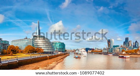 London, South Bank Of The Thames on a bright day in Autumn. Panoramic image taken from the Tower bridge.