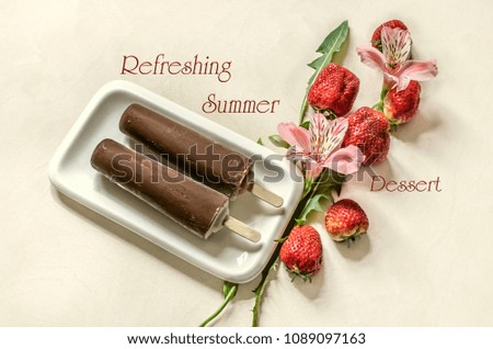 Two Popsicle ice cream on a stick covered with chocolate lie on a white plate near pink flowers with strawberries on a white table
