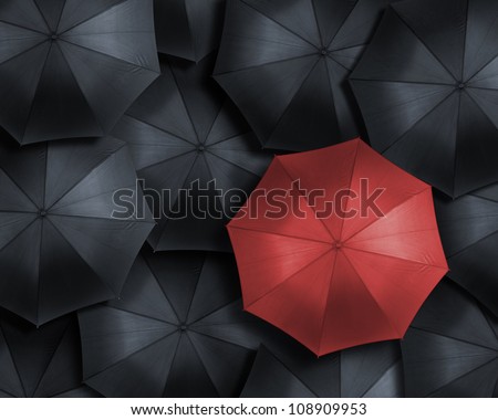 Standing out from the crowd, high angle view of red umbrella over many dark ones Royalty-Free Stock Photo #108909953