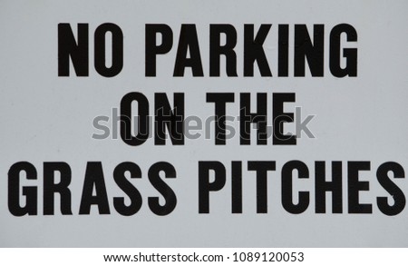 No parking on the grass pitches white sign with black text in capital letters