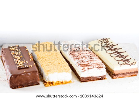 Beautiful Delicious dessert cheesecakes and chocolate cake on a white trendy background. Group of four different types of sweets.