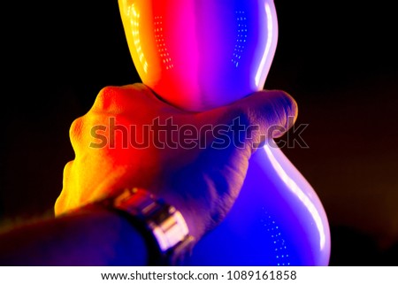 vase and hand with colorful lighting