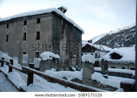 Snow city valley d'Aosta panoramic image covered in snow mountains with pine buildings ancient north of Italy.