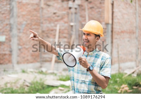 portrait of young man construction worker giving instruction to his employee Royalty-Free Stock Photo #1089176294