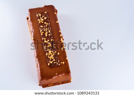Chocolate cake decorated with nuts on white background.View from above, copy space for text.