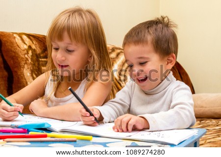 Cute children painting pictures at table indoors