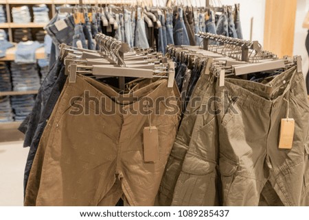 Shorts on the store shelf. Fashionable clothes on the shelves in the store. Shorts hanging on the vests in the fashion store. Showcase, sale, shopping.