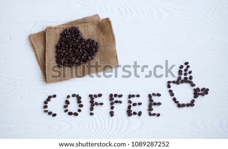 A word coffee made of coffee beans on the white table. background texture.