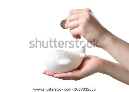 Woman hand lays a coin in a piggy bank airplane to save money for a trip.