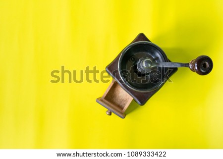 top view vintage wooden coffee grinder on yellow background