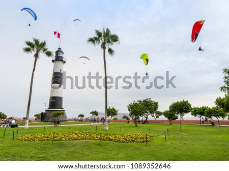View of La Marina Lighthouse (Faro de La Marina) in Miraflores district, with some paragliders in the sky, in Lima Peru