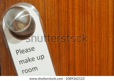 Please make up room sign hanging on the door knob  for housekeeping in a hotel