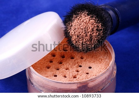 make-up powder with brush on blue background
