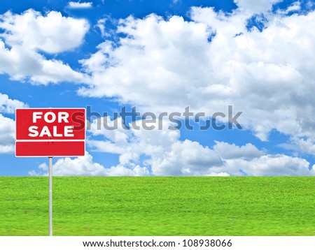 "LAND FOR SALE SIGN" on empty meadow - Real estate conceptual image