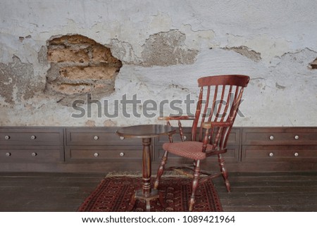 Old antique wooden chair and table in the room. Have a old wall.
