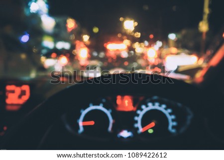 Inside car with bokeh lights from traffic on night in rainy day.