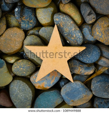 Wooden star icon on colorful pave rock