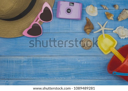 Top view Flat lay, Travel and vacation concept items on blue and wooden table background. with copy space, summer with camera and Beach accessories