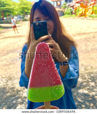 Woman take photo colorful ice cream by mobile phone at attention
