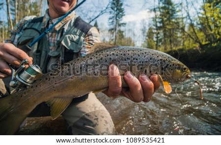 Fisherman holding brown trout