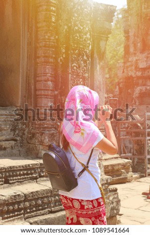 travel concept, soft photo asian woman standind traveler taking selfie on archaeological site.
