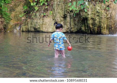 The child bathing in the lake. A little girl in the water. Summer.